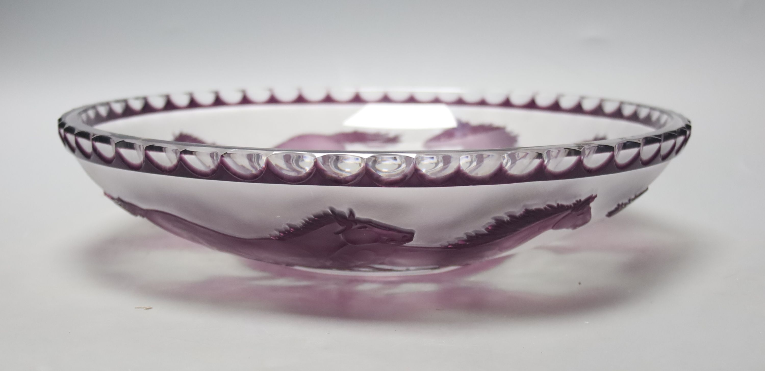 An amethyst overlaid glass fruit bowl, decorated with horses, height 34cm